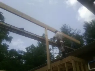 Carpenter setting a ridge beam over a new addition frame — Ice Dam Removal by Roofing Brothers in Blue Grass