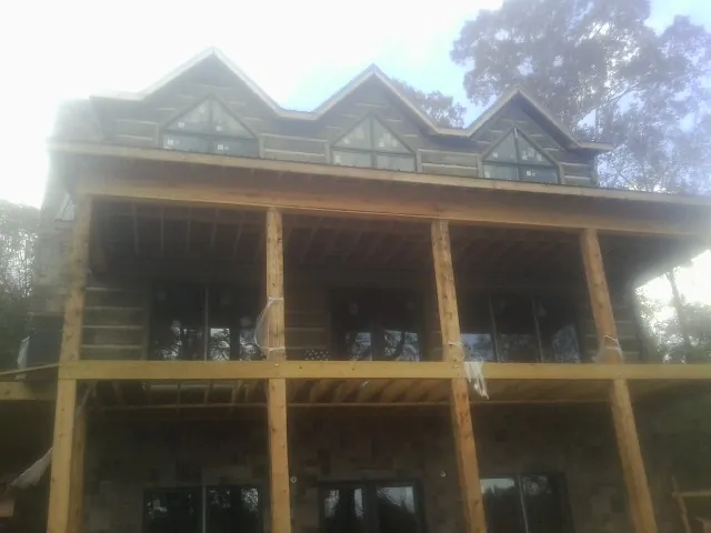 Dormers and porch framing on a large log home under construction — Roof Coating work by our crew in Blue Grass