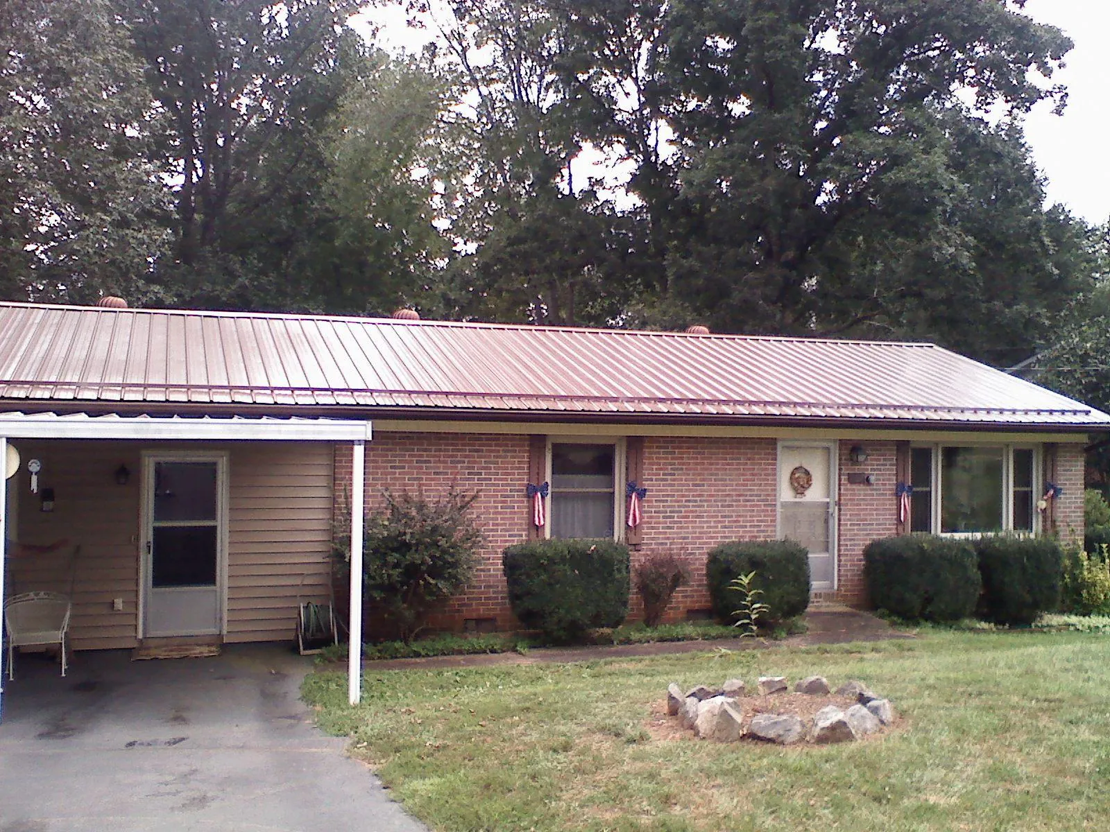 Bronze metal roof and carport on a brick ranch home — Roof Repair work by our crew in Blue Grass